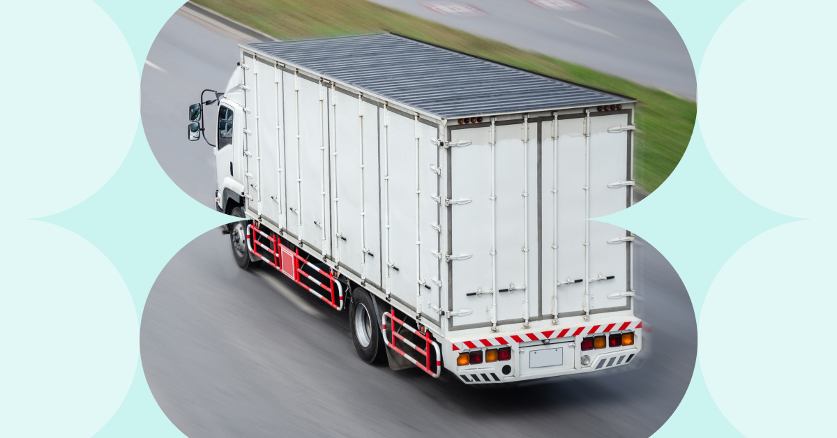 A white truck operating in cold chain logistics driving on the road.