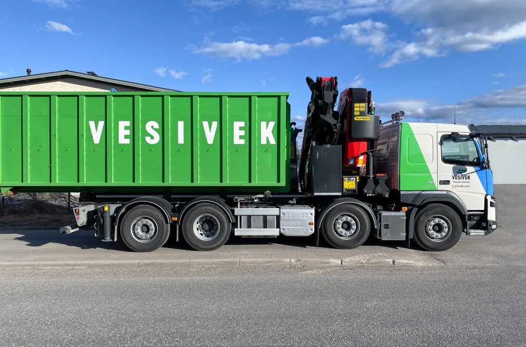 A large green Vesivek truck with the company's name seen on the side of the trailer.