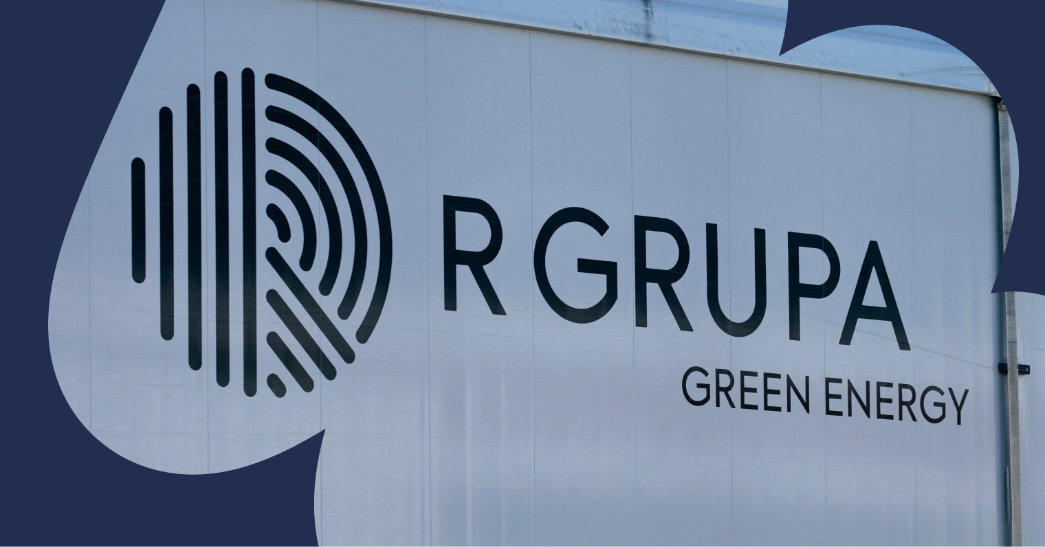 Baltas sunkvežimis su dideliu logotipu, ant kurio užrašyta R GRUPA Green Energy.