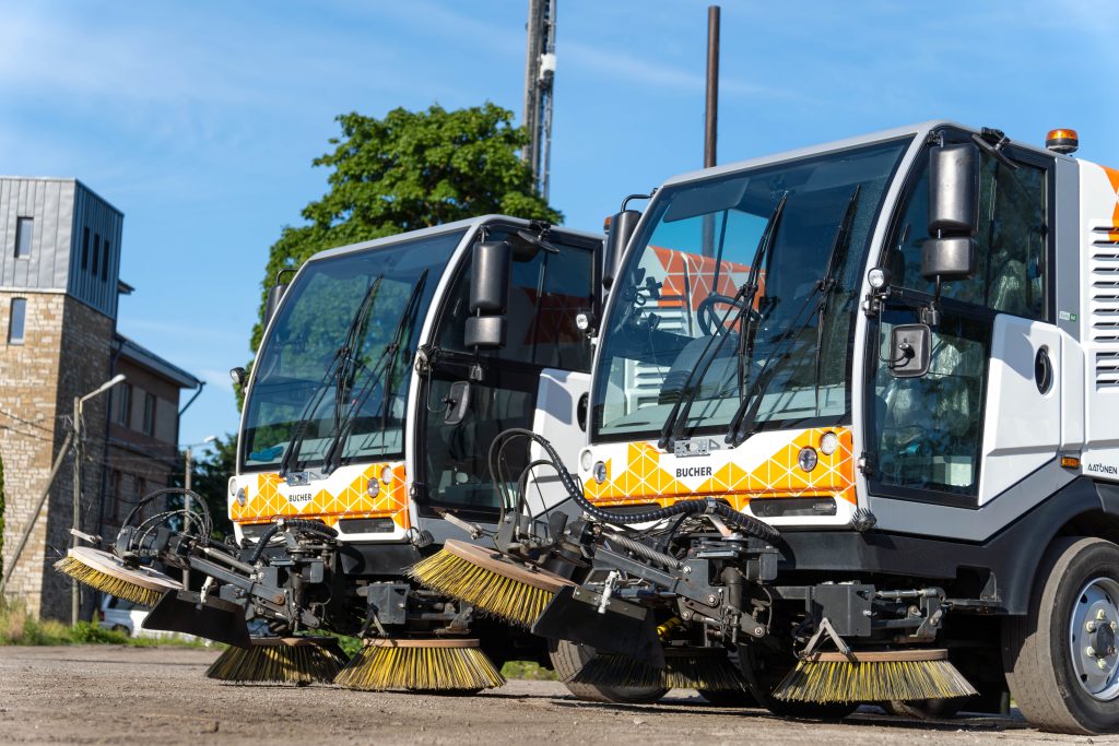 Bucher sweepers equipped with cameras are parked on a sunny day.