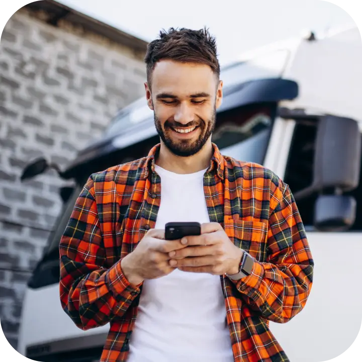 Un joven mira su smartphone con la aplicación para conductores de flotas Mapon Driver instalada.