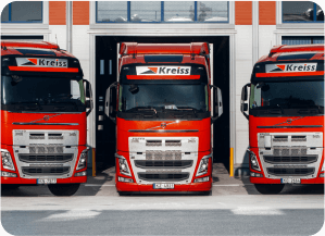 Three red long haul trucks of transport company Kreiss.