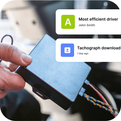 Autoelektriķis tur rokā melnu Mapon Expert GPS izsekošanas ierīci, kas ir savienota ar kravas transportlīdzekli.