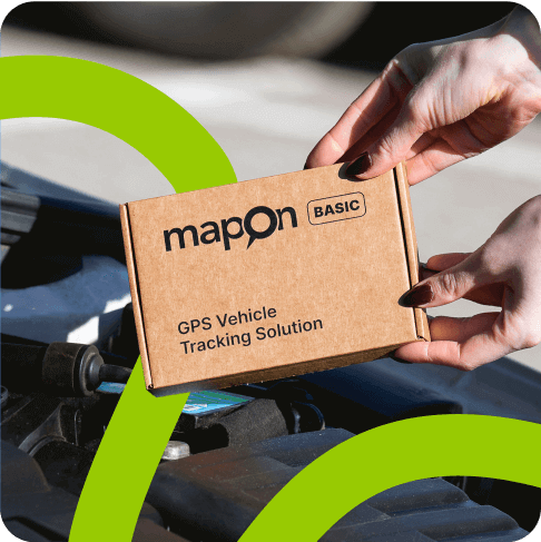 An employee holding a cardboard box with "Mapon Basic GPS Vehicle Tracking Solution" written on it.