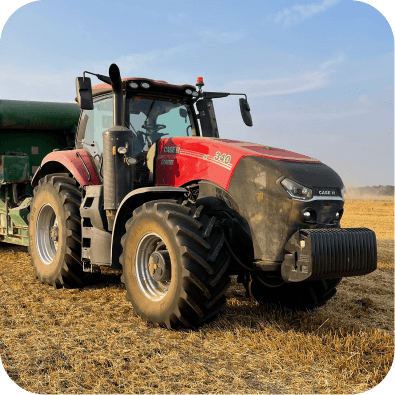 A large red tractor working  the fields.