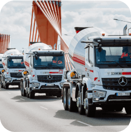 A column of three white cement mixer trucks with Schwenk logos.