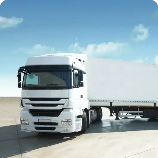 A white truck with a white trailer parked outside.