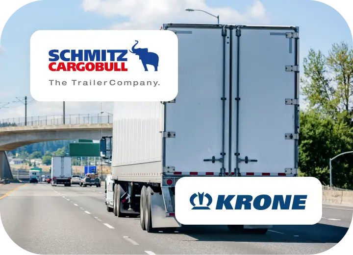 Un camión blanco con un remolque blanco circulando por una autopista, se ven los logotipos de Schmitz Cargobull y KRONE alrededor del remolque.